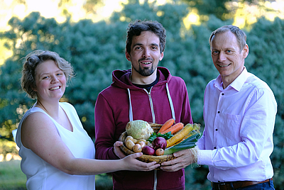 Ein duftender Korb mit Biogemüse wurde als Vorgeschmack von MORGENTAUGÄRTEN-Initiator und Biopionier Christian Stadler (rechts) und der neuen Projektleiterin Sophie Pogats an Simon Fischer überreicht